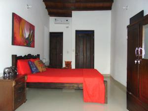 1 dormitorio con 1 cama con colcha roja en Hostal Santa Maria City, en Santa Marta