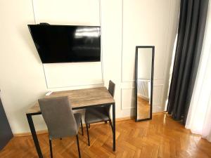 a table with a chair and a television on a wall at Aparthotel Mtatsminda in Tbilisi City +21 photos