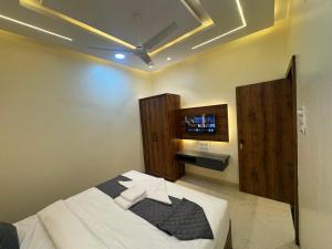 a bedroom with a bed and a tv on the wall at Hotel Tulsi inn in Ellora