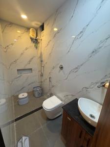 a bathroom with a toilet and a sink at Hotel Tulsi inn in Ellora