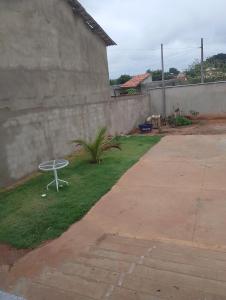 een witte tafel op het gras naast een muur bij Excelente casa in Búzios