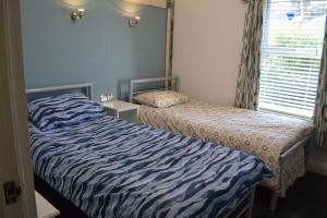 een slaapkamer met twee bedden en een raam bij Marine Haven in Ballycastle