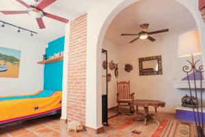a room with a bed and a table and a ceiling fan at Finca Luna Serena in San Miguel de Allende