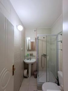 Un baño con ducha, lavabo e inodoro. en Felicia Apartments, en Budva