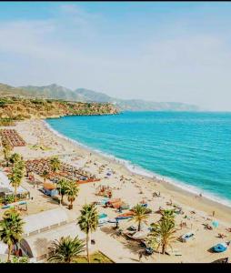 una playa con gente, palmeras y el océano en 2 minutes from the beach!!! Great apartment!!!, en Nerja