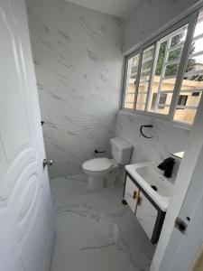 une salle de bain blanche avec un lavabo et des toilettes dans l'établissement Apartamento 2, à Cancino