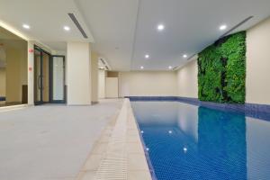 a swimming pool in a building with a green wall at Modern Furnished Apartments in Istanbul Basaksehir By Iradah Gayrimenkul in Basaksehir