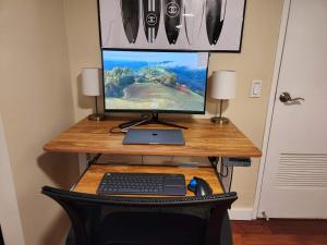 a computer monitor and a keyboard and mouse on a desk at Makaha Valley Oasis 1-Bedroom apts in Waianae