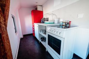 een keuken met een wit fornuis en een rode koelkast bij Moderner Altbau für 3 in Maagdenburg