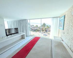 a living room with a tv and a large window at We Hotel Acapulco in Acapulco +61 photos