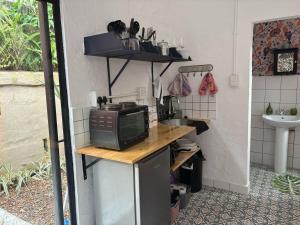 a small kitchen with a microwave on a counter at Studio at 142 in Durban