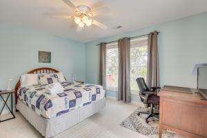 Waterfront Oak Island Home with Dock في أوك آيلاند: غرفة نوم بسرير ومكتب وبيانو