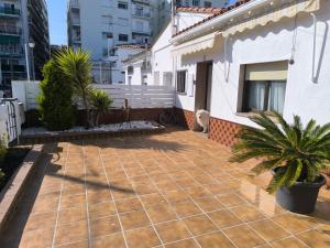 a patio with palm trees and a house at Casa junto al mar in Blanes