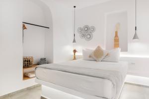 een witte slaapkamer met een wit bed en een bad bij August Mykonos in Mykonos-stad