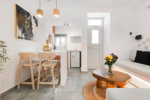 een keuken en woonkamer met een tafel en stoelen bij August Mykonos in Mykonos-stad