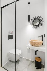 een badkamer met een toilet en een spiegel bij August Mykonos in Mykonos-stad +48 foto's