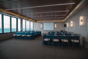 Una sala de conferencias con mesas, sillas y una pantalla. en MantaHost Hotel, en Manta 44 fotos más