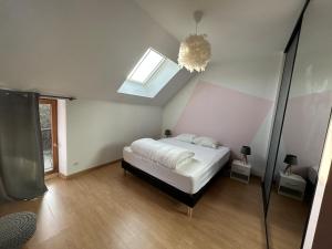 a bedroom with a bed and a skylight at Maison de ville, Gien centre in Gien