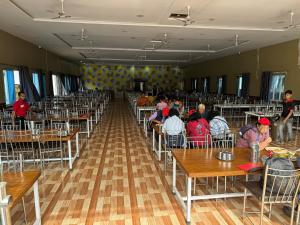 a group of people sitting at tables in a room at Hotel Tulsi inn in Ellora