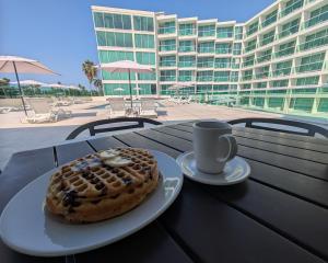 a waffle and a cup of coffee on a table at We Hotel Acapulco in Acapulco