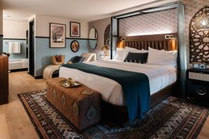 a hotel room with a large bed and a table at UNCOMMONER HOTEL by Reverie Boutique Collection in West Yarmouth