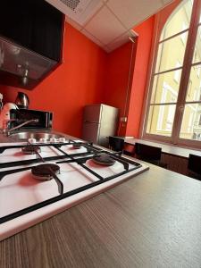 a stove top in a kitchen with an orange wall at Andres Guest House Sanremo in Sanremo +11 photos