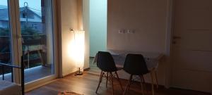 a room with two chairs and a table with a window at Villa Nathanael Cozy Rooms with Balcony in Pogradec