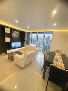 a living room with a white couch and a table at Residencias Tandil Centro con vistas - Pinto in Tandil