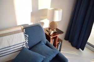 sala de estar con silla azul y lámpara en Merveilleux, sur la plage et accès direct à la mer, en Olmeto
