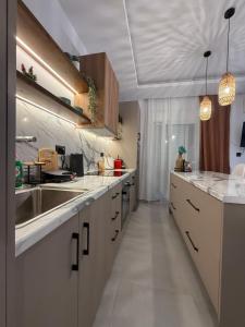 a large kitchen with white counters and a sink at Meraki Apartment in Kremasti