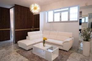 a living room with a white couch and a table at La Galleria Milano - 160 sqm Design Apartment, Spa & Parking in Milan +8 photos
