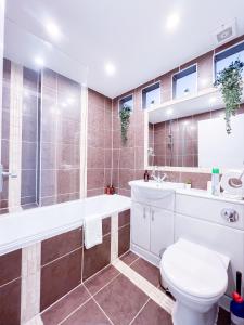 ein Badezimmer mit Toilette, Badewanne und Waschbecken in der Unterkunft The Fitz Central Apartment in London
