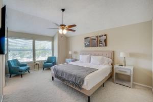 Flower MoundにあるMelody Home near Grapevine DFW Airport w backyardのベッドルーム1室(ベッド1台、椅子2脚、シーリングファン付)