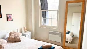 una camera da letto con specchio, letto e finestra di The Bristol Vault a Bristol