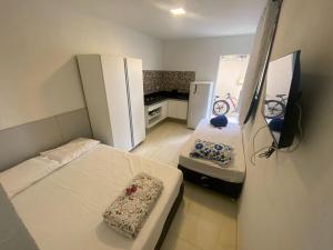 a small room with two beds and a refrigerator at Casa de Cond - Villas de Jacuípe in Camaçari +28 photos