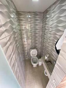 a small bathroom with a toilet in a stall at Casa de Cond - Villas de Jacuípe in Camaçari