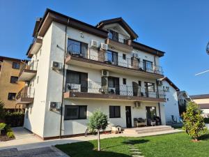 an apartment building with balconies and a yard at Vila Kos in Mamaia Sat/Năvodari