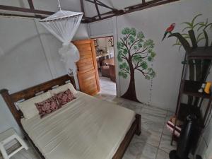 a bedroom with a bed with a tree painted on the wall at Boca Tapada Inn in Boca Tapada