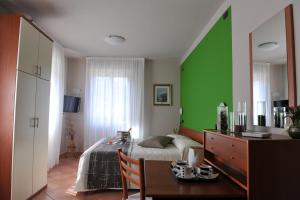 a bedroom with a bed and a green wall at Hotel Bellavista Meublè in Monte Isola