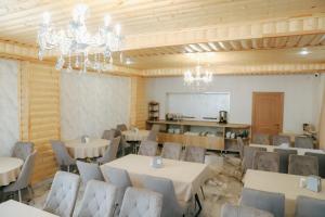 a dining room with tables and chairs and chandeliers at HarMar Hotel in Goris