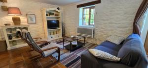 a living room with a blue couch and a tv at Gites Ferme de la Baie in Roz-sur-Couesnon