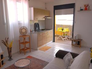 a living room with a couch and a kitchen at Nid d'Aigle Tropical in Rivière-Salée