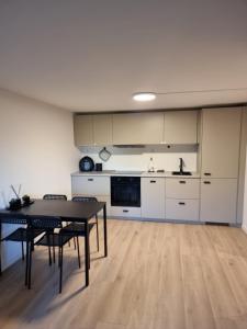 a living room with a table and a kitchen at Near Bergen City, Apartment 7 min from the airport, free parking in Bergen