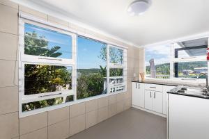 a kitchen with white appliances and large windows at Bo Kant - Hooggety in George
