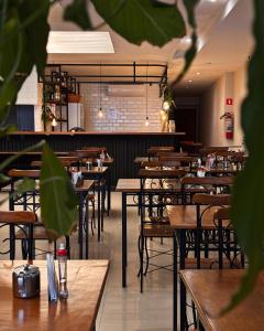 ein Restaurant mit Tischen und Stühlen und einer Bar in der Unterkunft HMG Rio Suítes in Rio de Janeiro