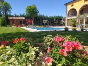 a yard with flowers and a swimming pool at Tanca RE in Fabbrico