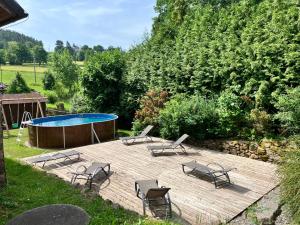 a deck with chairs and a swimming pool and a table at Mlýn Kamenice in Klučenice