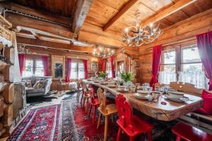 una sala da pranzo con un lungo tavolo e sedie rosse di BAJKOWA FOLK Jacuzzi Zakopane a Murzasichle
