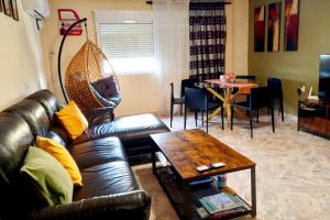a living room with a leather couch and a table at Cozy Flat with City & Beach in Puerto de Sagunto