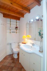 a bathroom with a white sink and a toilet at La casina in Porrúa +21 photos